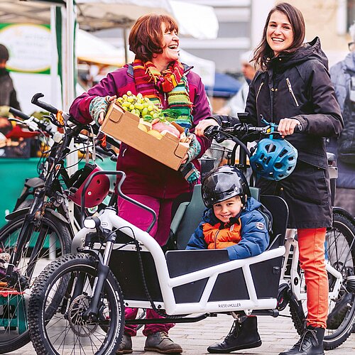 [Translate to Englisch:] Familie beim Radfahren in der Villacher Innenstadt