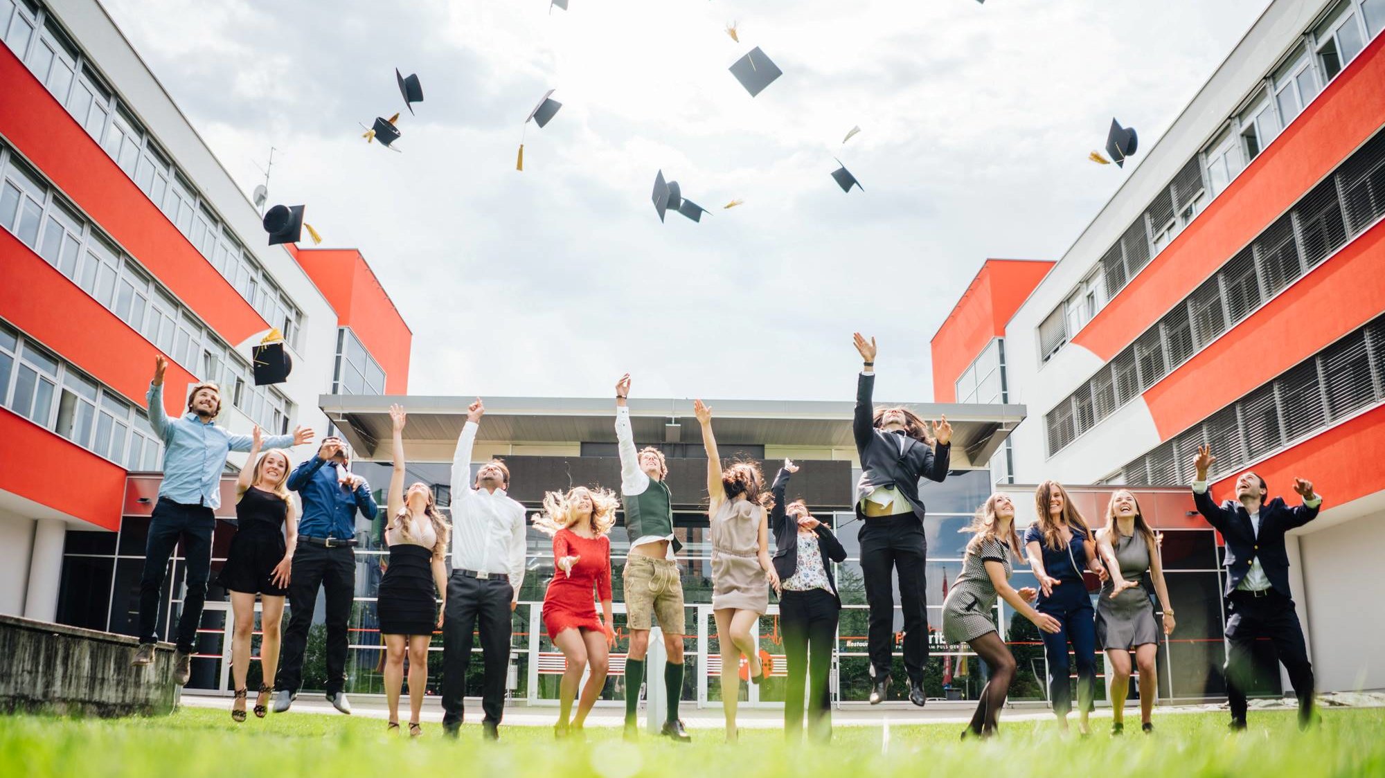 Studierende werfen nach der Abschlusszeremonie ihre Hüte in die Luft 