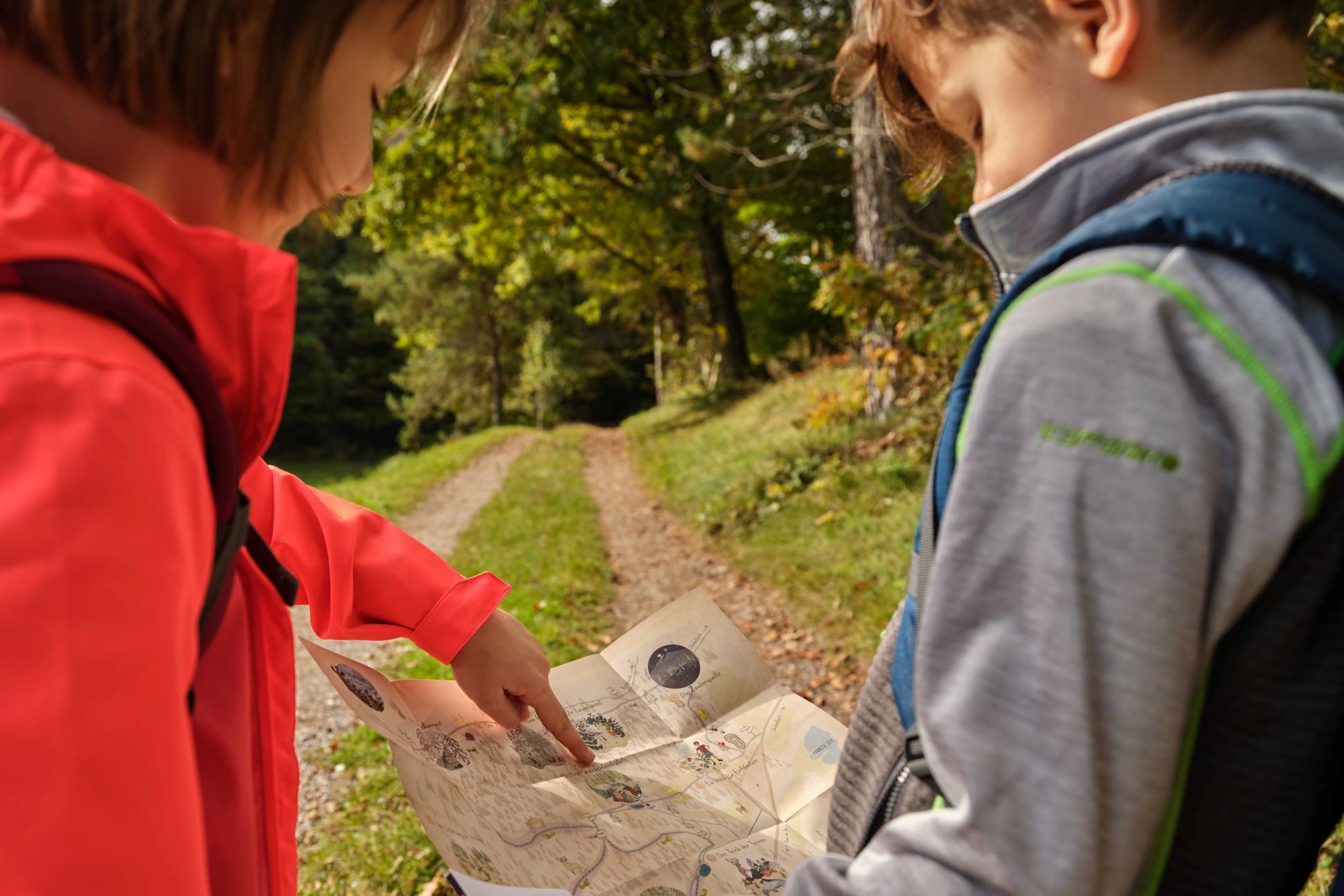 Kinder schauen in die Karte von der Woroun-Wanderung