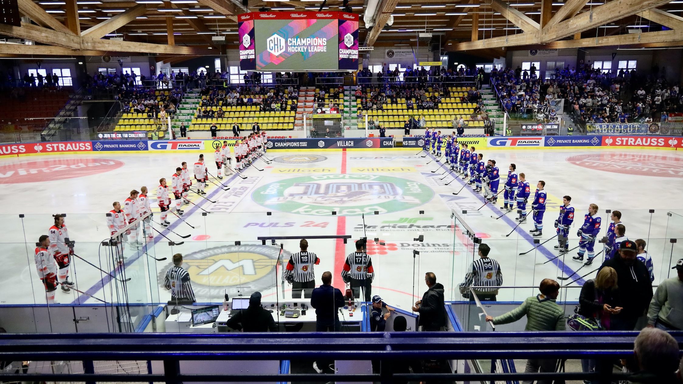 Two ice hockey teams are facing each other on the ice