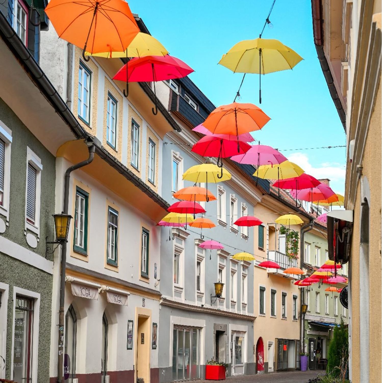 Bunte Regenschirme über einer Gasse