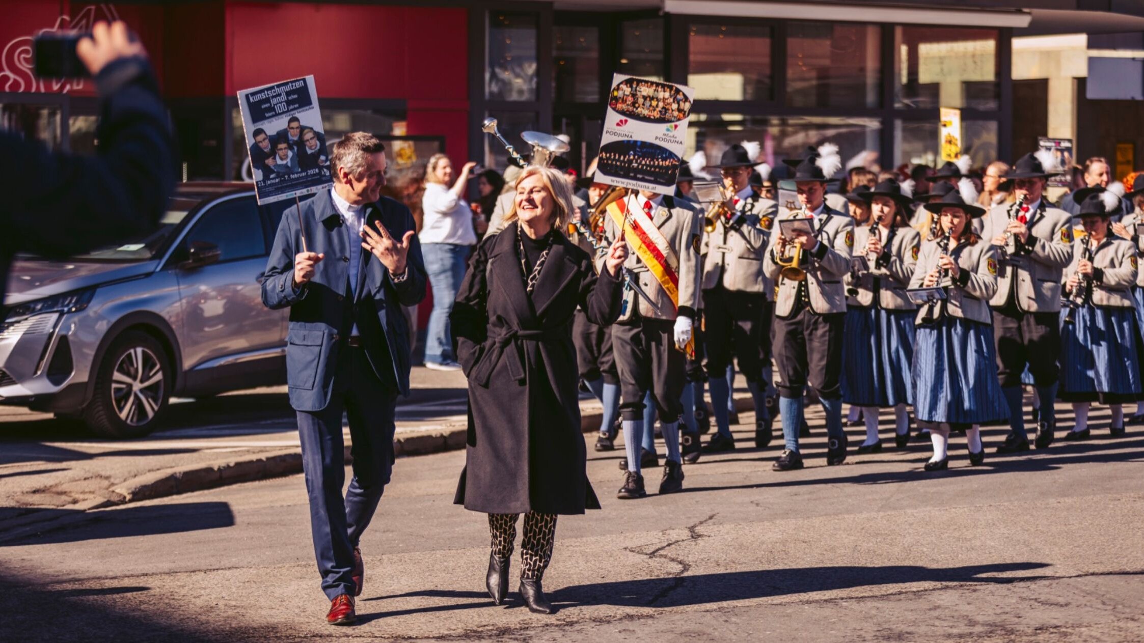 Jauntaler Trachtenkapelle mit Fahrgästen der Westbahn-Premierenfahrt ziehen in den Bahnhofsvorplatz ein