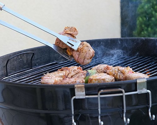 Grillzange mit Fleisch und Griller