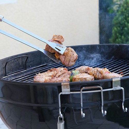Barbecue tonges with meet and griller