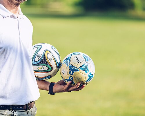Soccer Trainer holding the balls