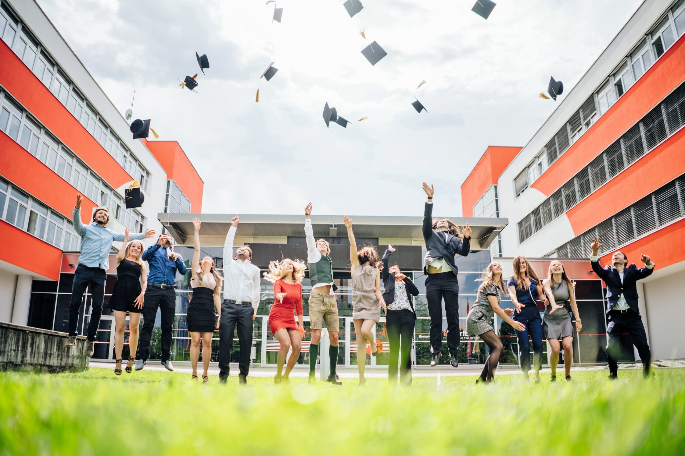 Studierende der FH Villach schmeißen bei ihrer Abschlussfeier ihre Hüte in die Luft