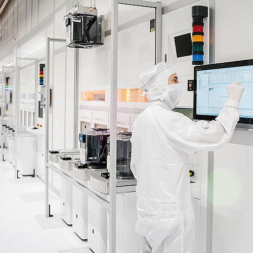 Researcher in the clean room of Infineon Austria