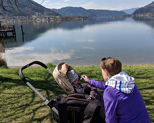 Mother feeds baby in the baby buggy in Villach