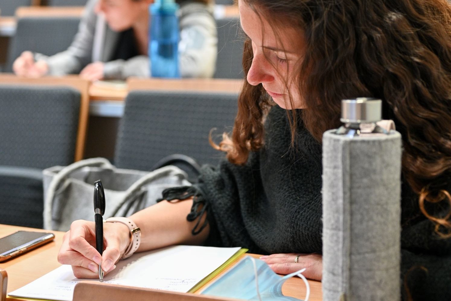 Woman takes notes during class