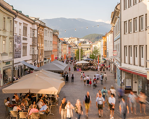 People going for a walk and drinking coffee at Villach's Hauptplatz