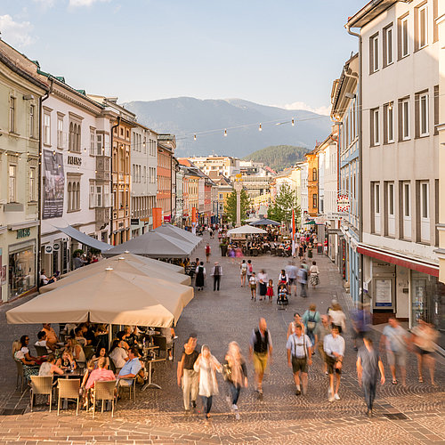 People going for a walk and drinking coffee at Villach's Hauptplatz
