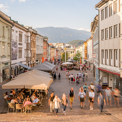 Menschen spazieren und trinken einen Kaffee am Villacher Hauptplatz