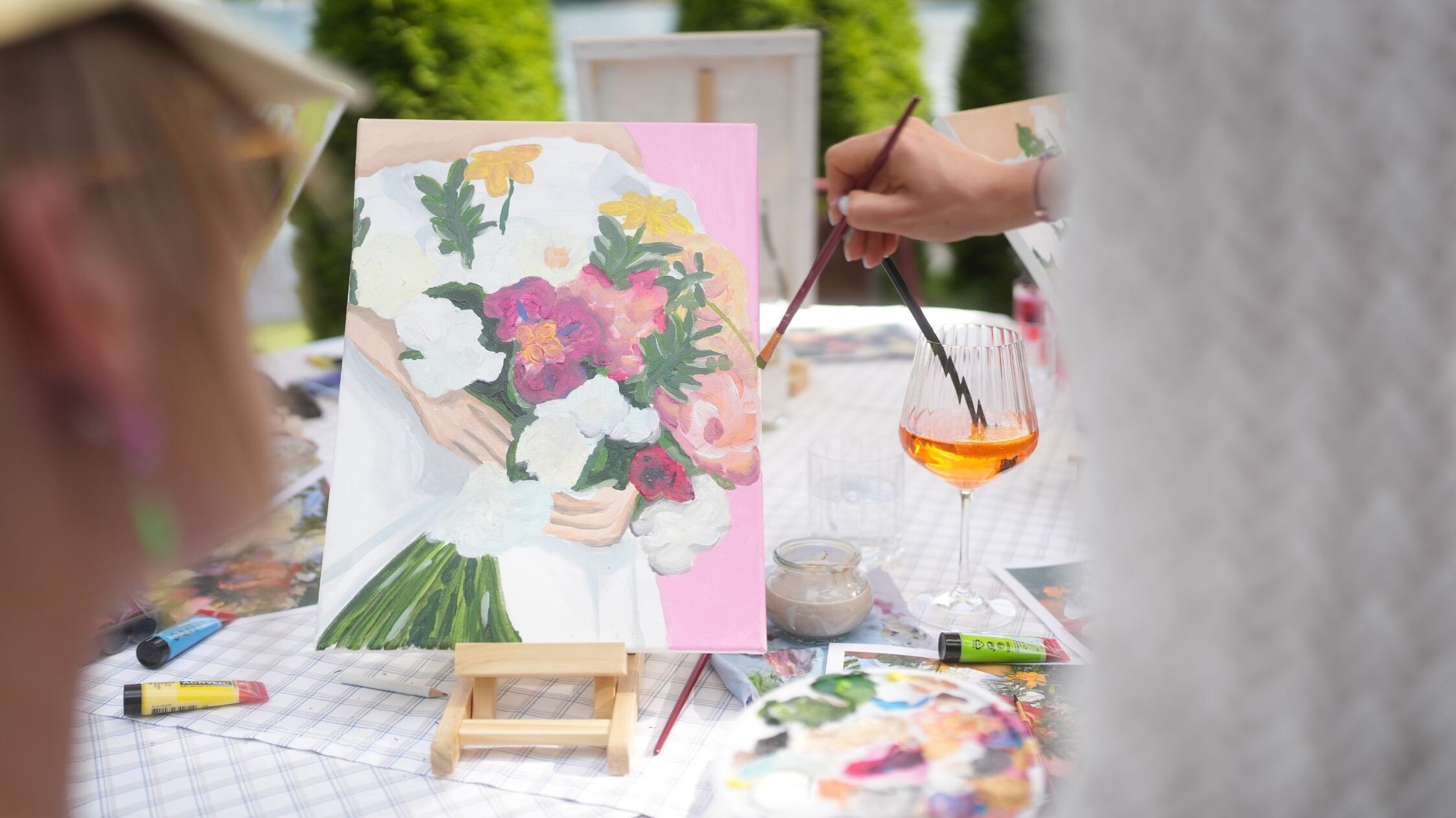 A hand painting a picture with a brush