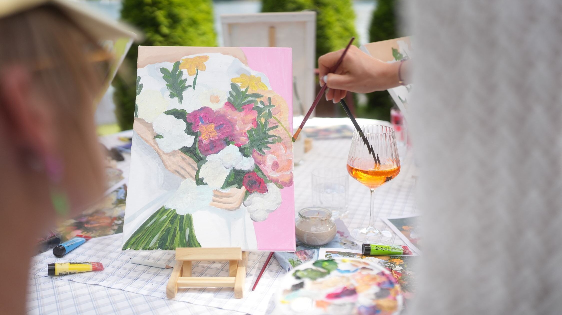 Malworkshops in Villach Hand streicht mit einem Pinsel Farbe auf ein Bild