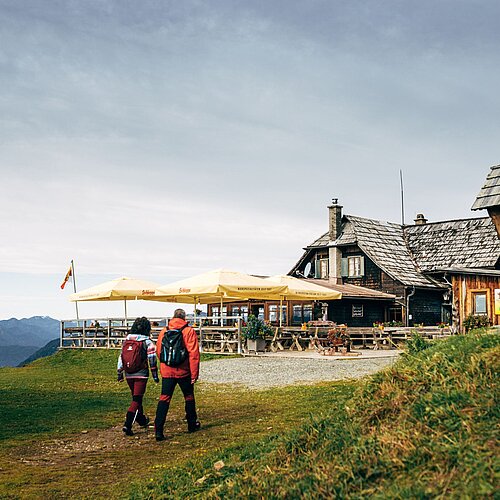 Two people in front of hut on mountain