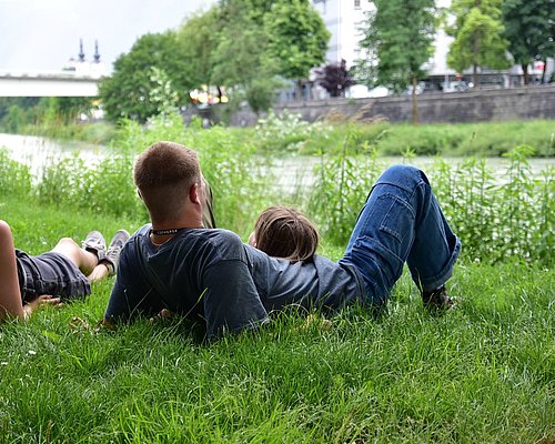 Familie liegt in einer Wiese des Drauufers