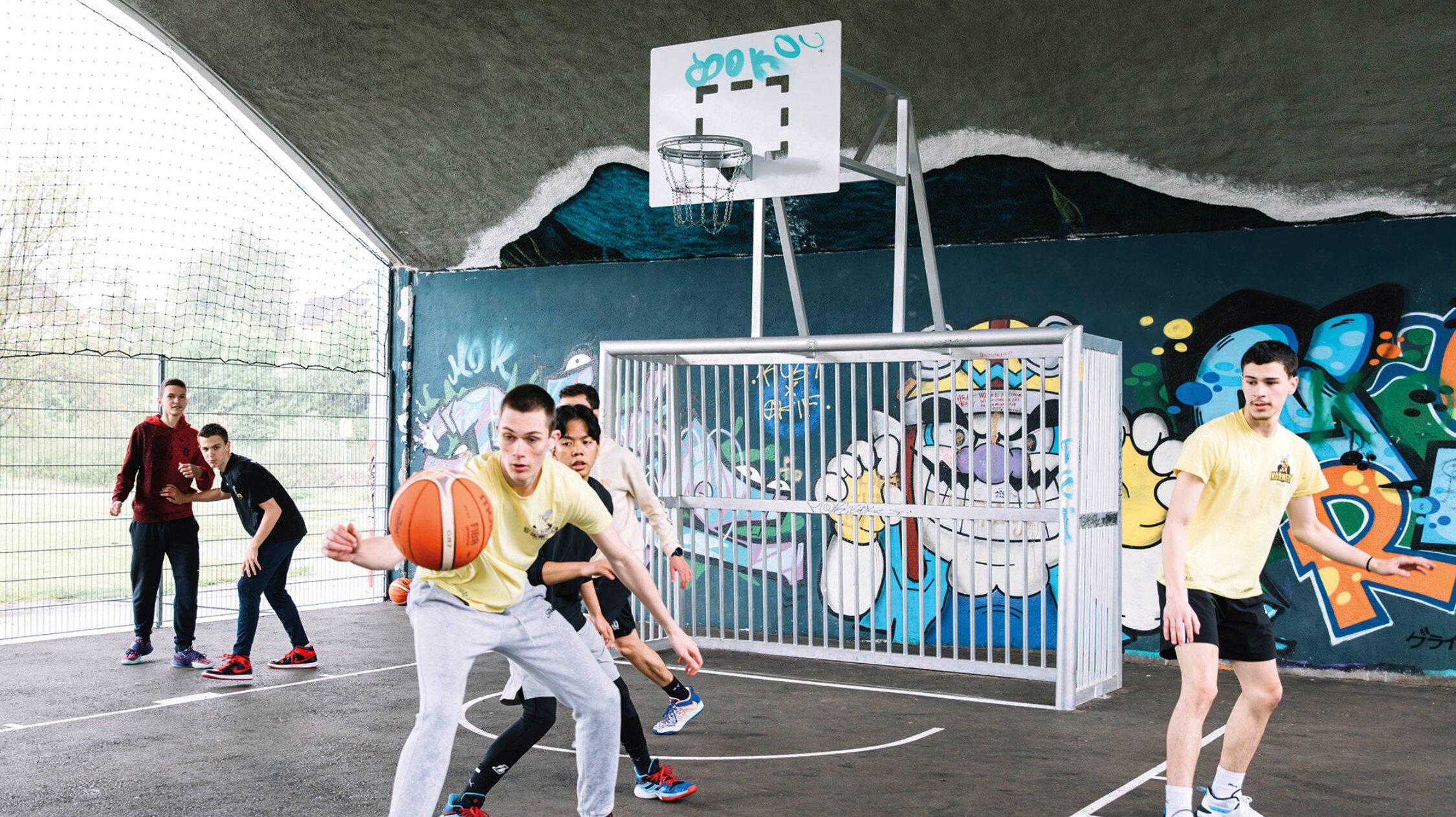 Jugendliche beim Basketballspielen unter der Kriegsbrücke in Villach