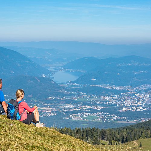 Wanderer genießen den Ausblick auf Villach vom Naturpark Dobratsch