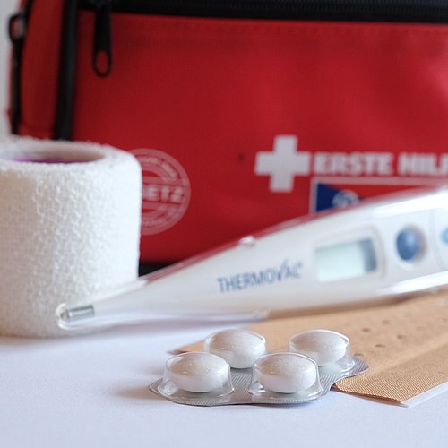 Hausapotheke mit Tabletten, Fieberthermometer und Pflaster