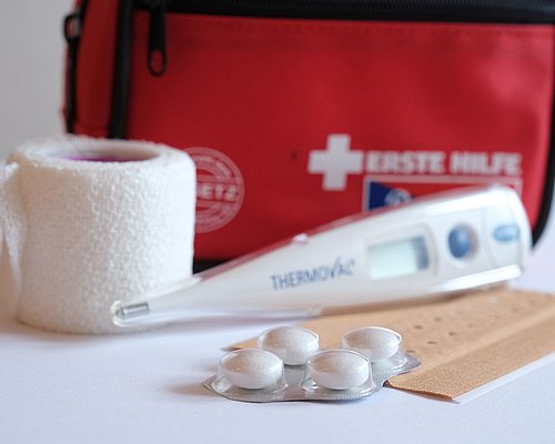 Hausapotheke mit Tabletten, Fieberthermometer und Pflaster