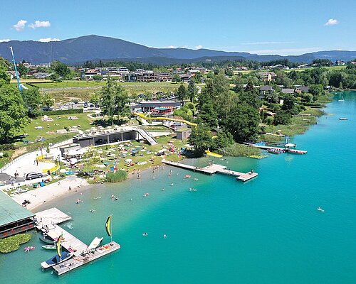 Der türkisblaue Faaker See mit dem Strandbad Drobollach aus der Vogelperspektive