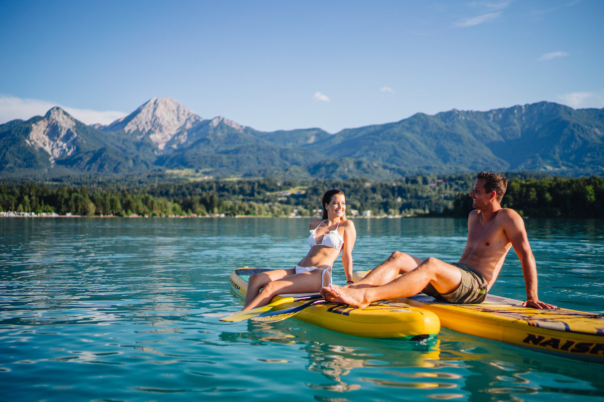 Stand-Up paddler sitting on the board on a lake