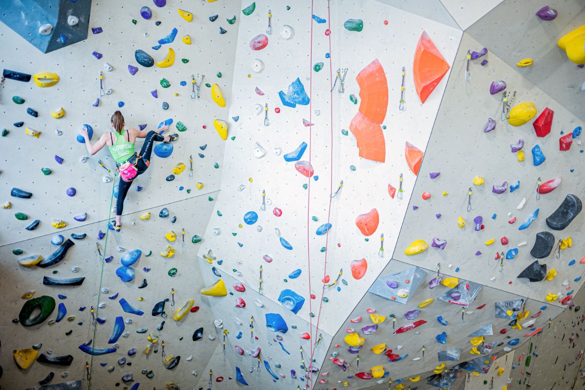 Climber is ascending the indoor climbing wall