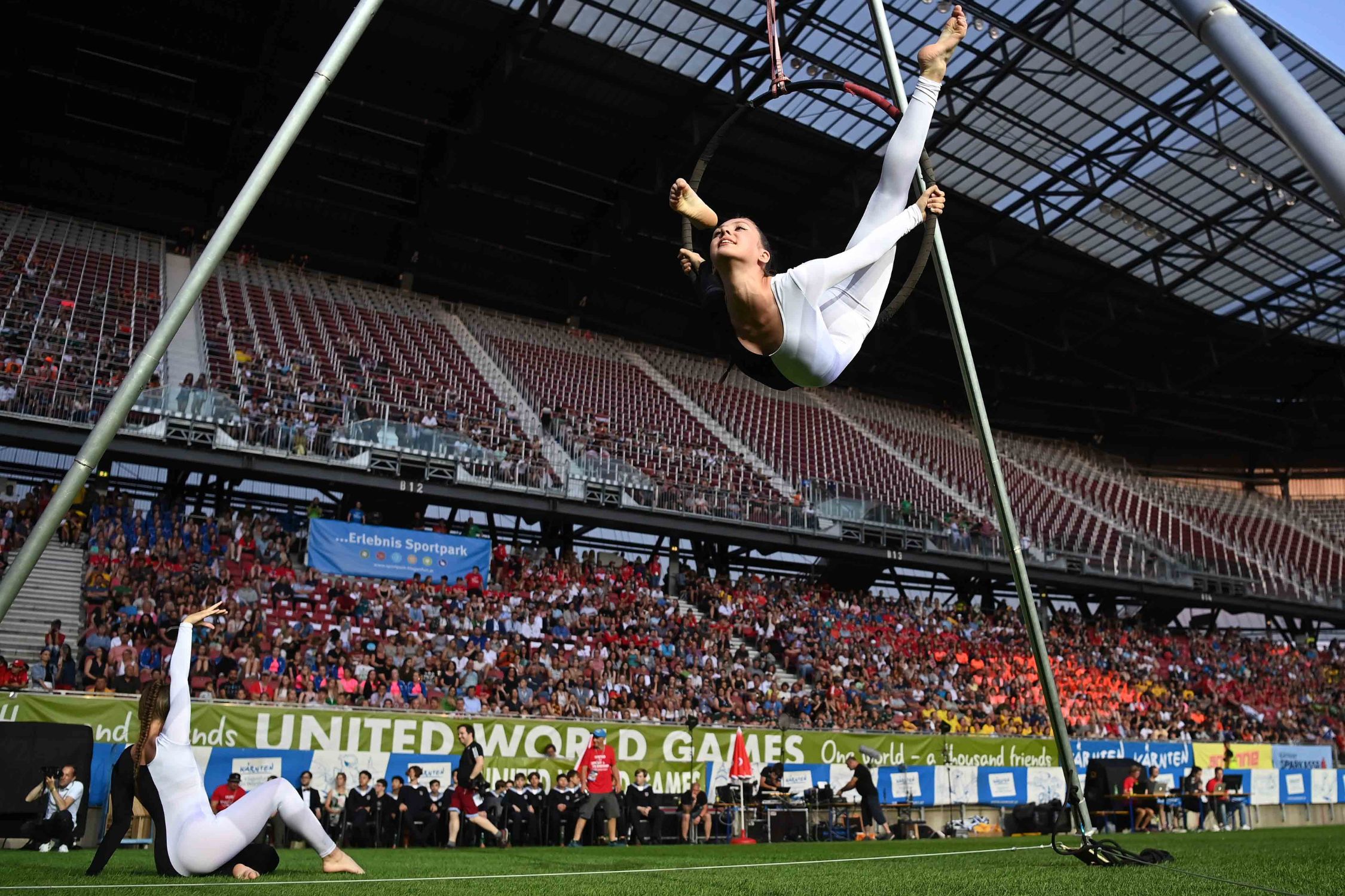 Young acrobat with audience in the background at the United World Games