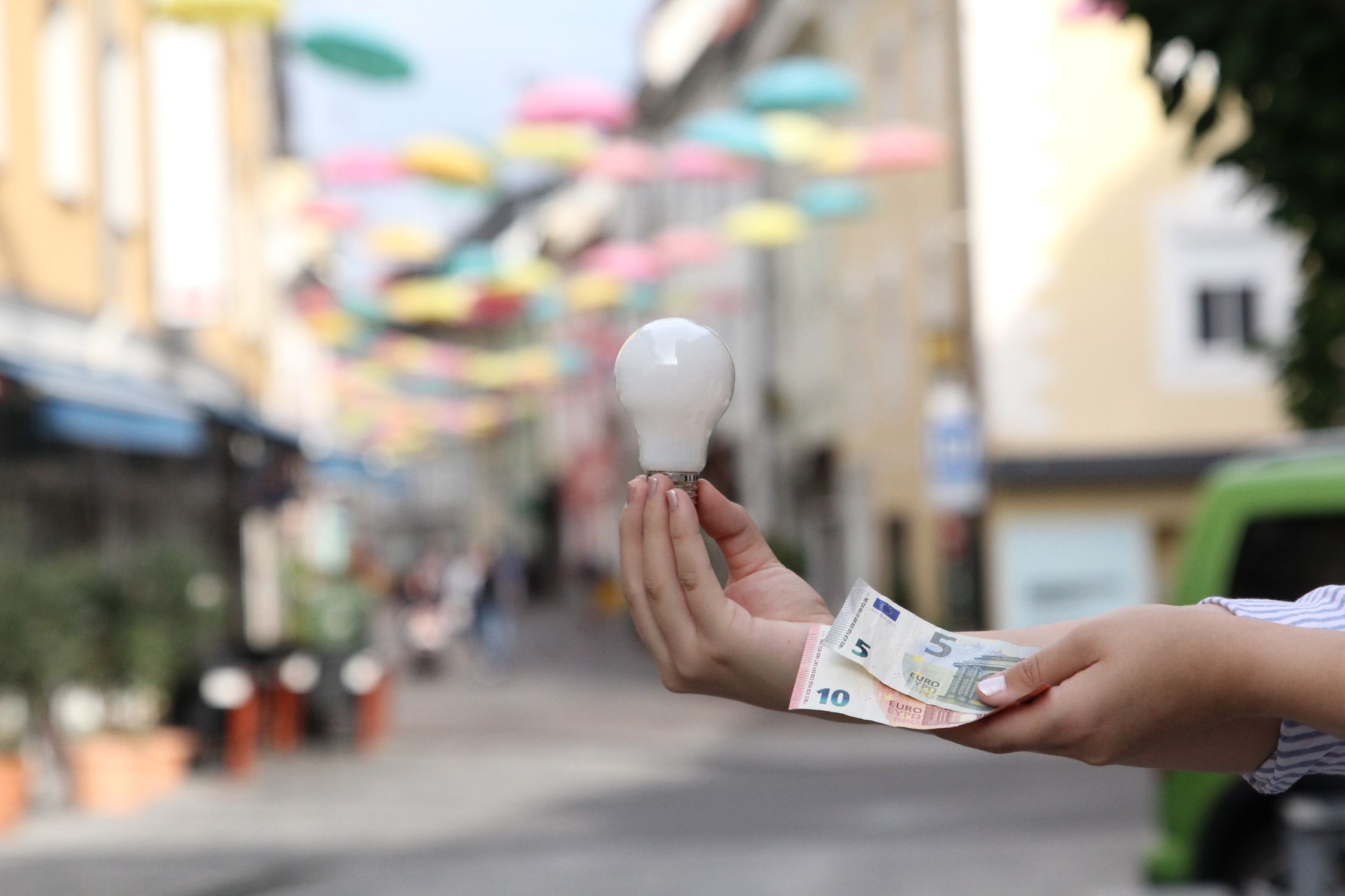 Hands with money and a light bulb