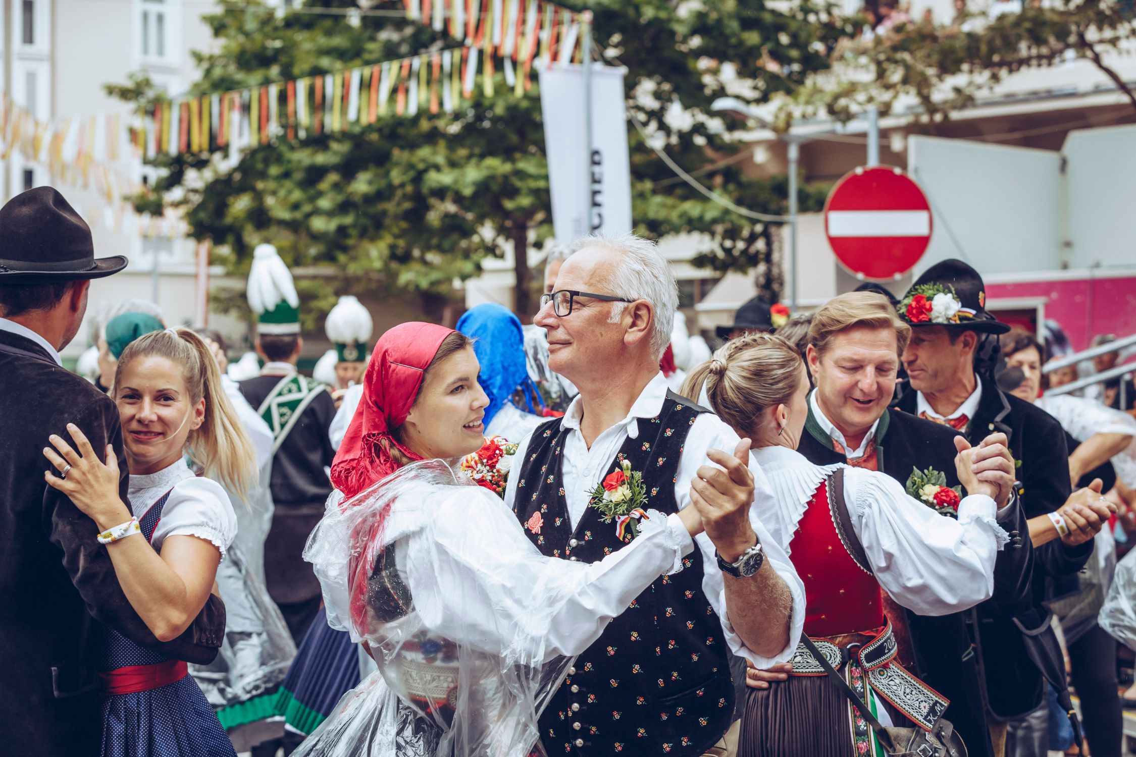 Dancing people in dirndl and lederhosen