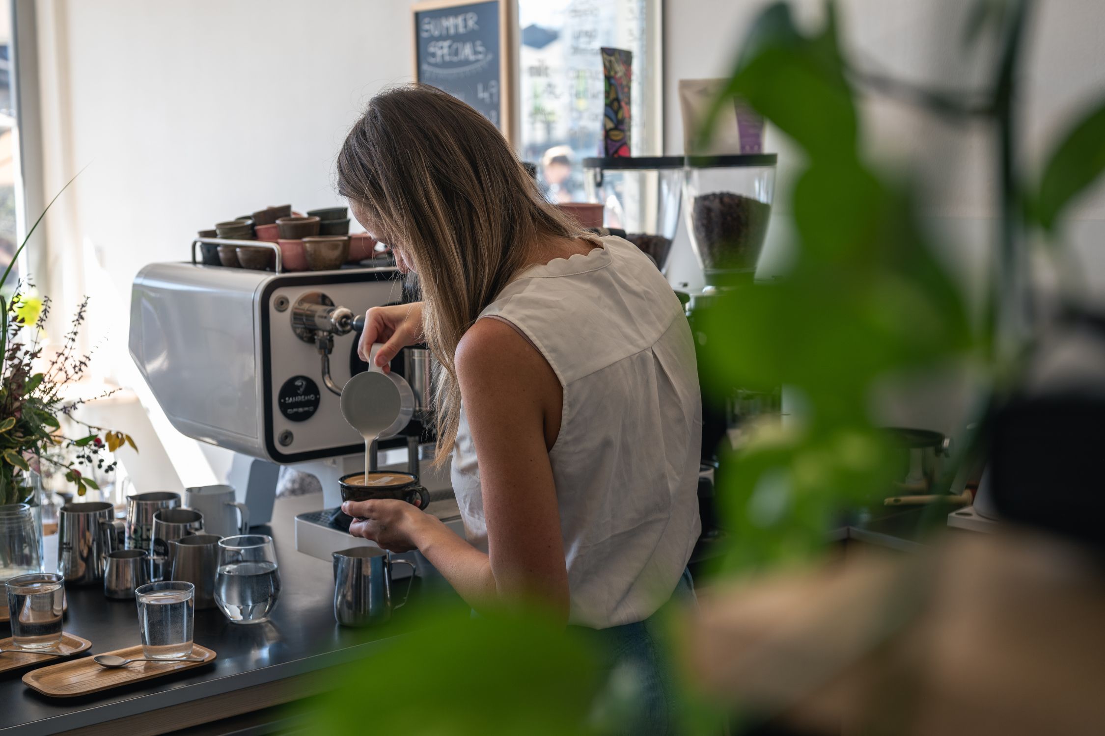 Frau bereitet an einer Siebträgermaschine einen Kaffee im Specialty-Coffee-Shop Biest zu