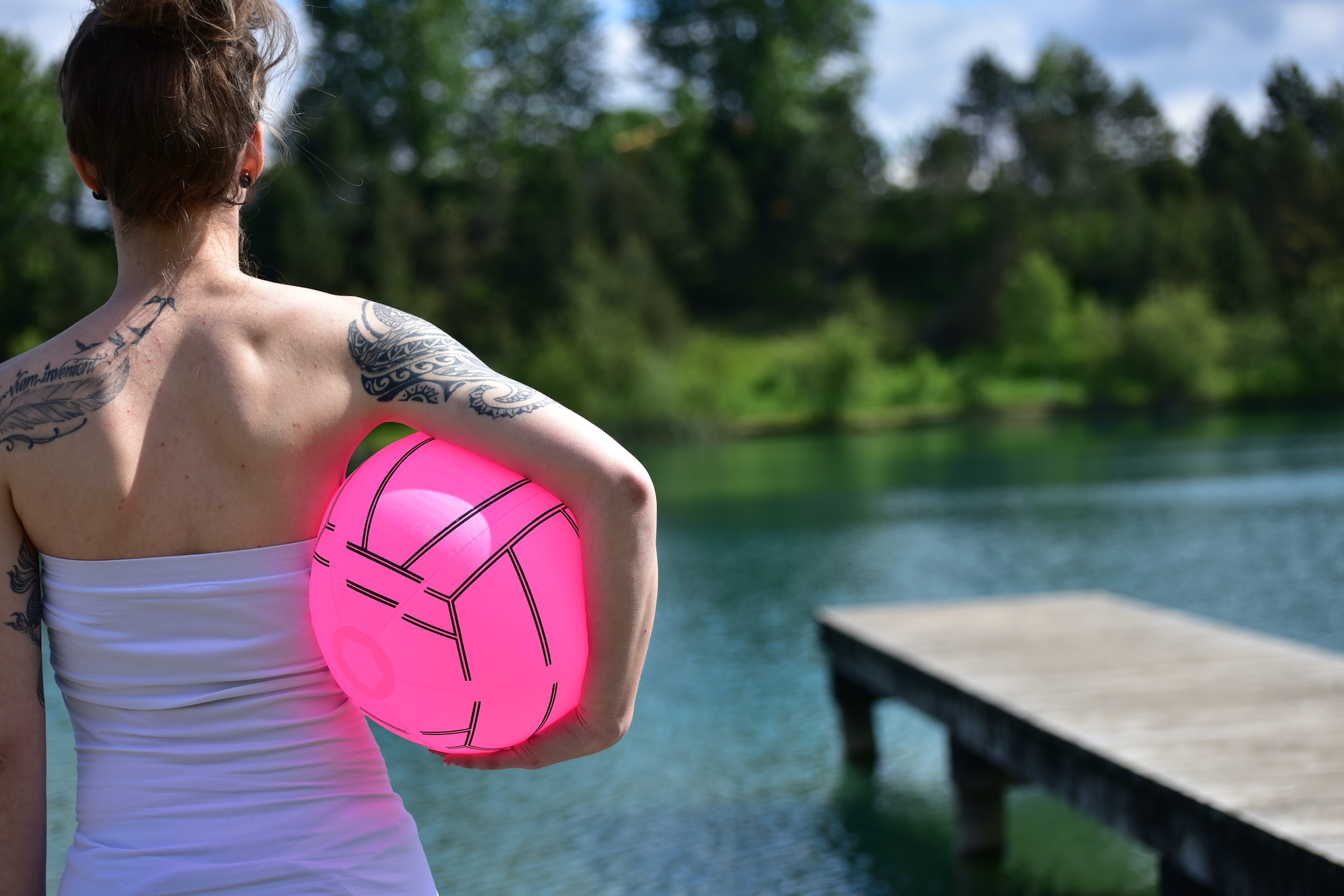 Girl holding a ball at the lake