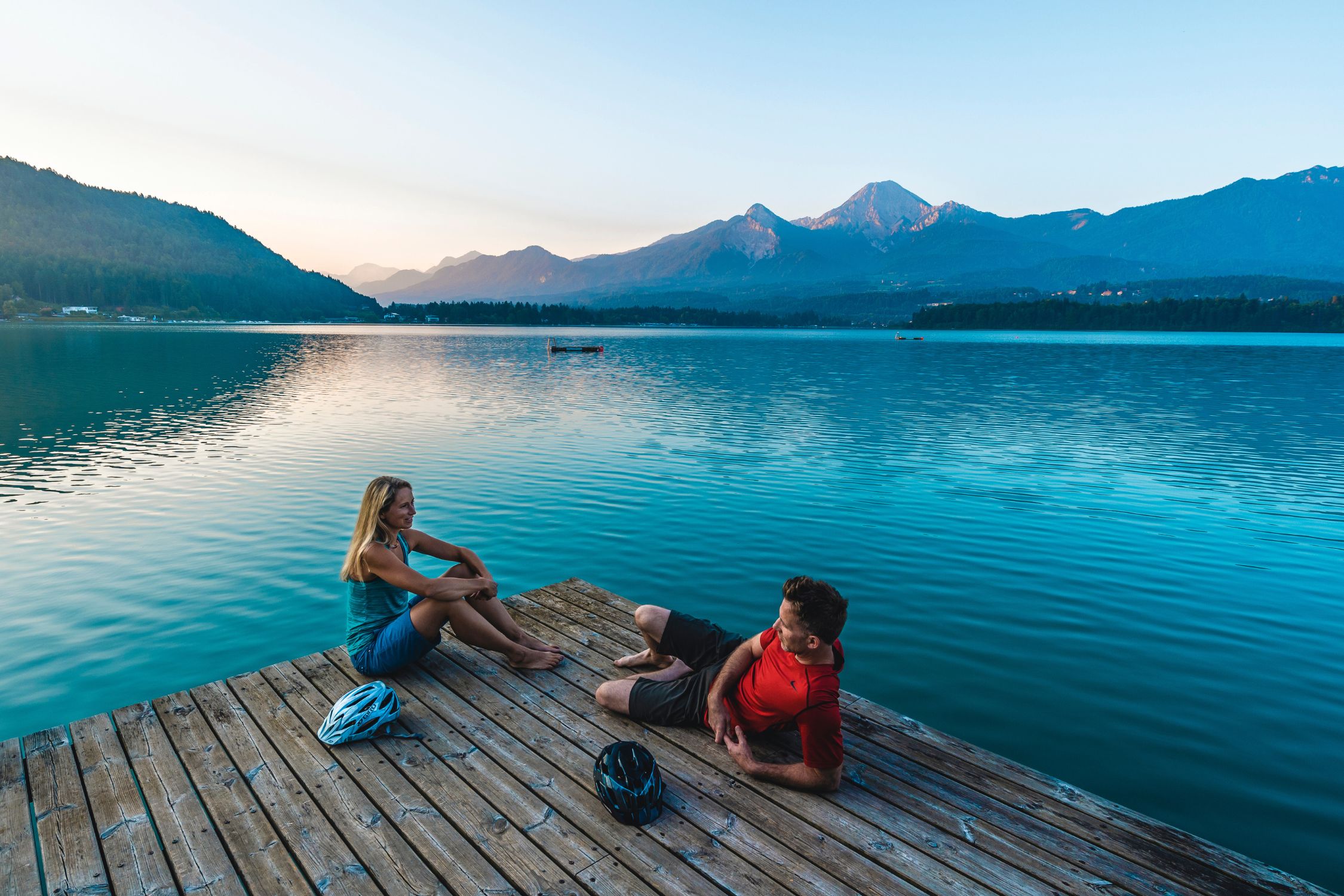 Cyclists relaxing on a jetty at Lake Faaker See