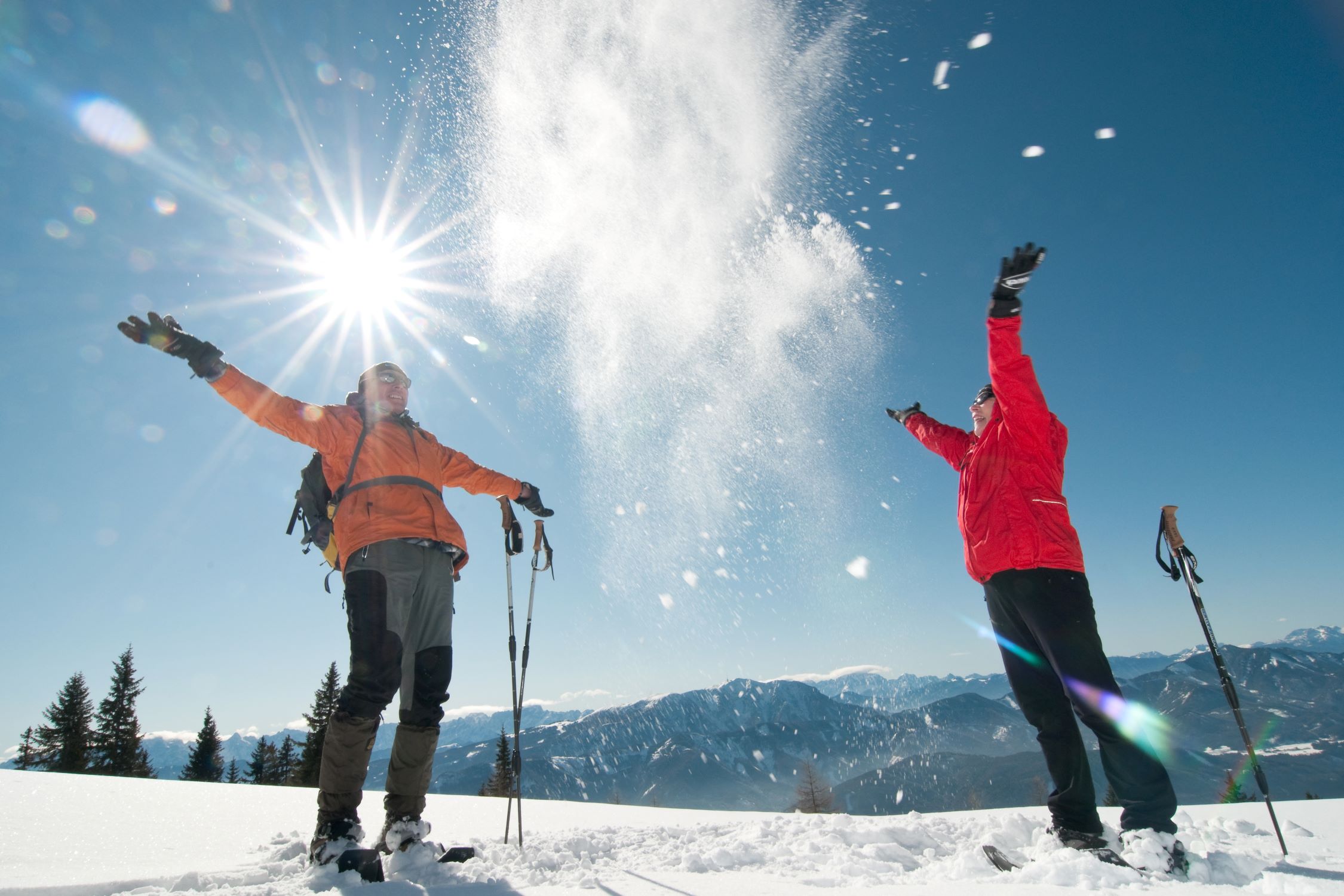 Snow shoe hikers throw snow into the air