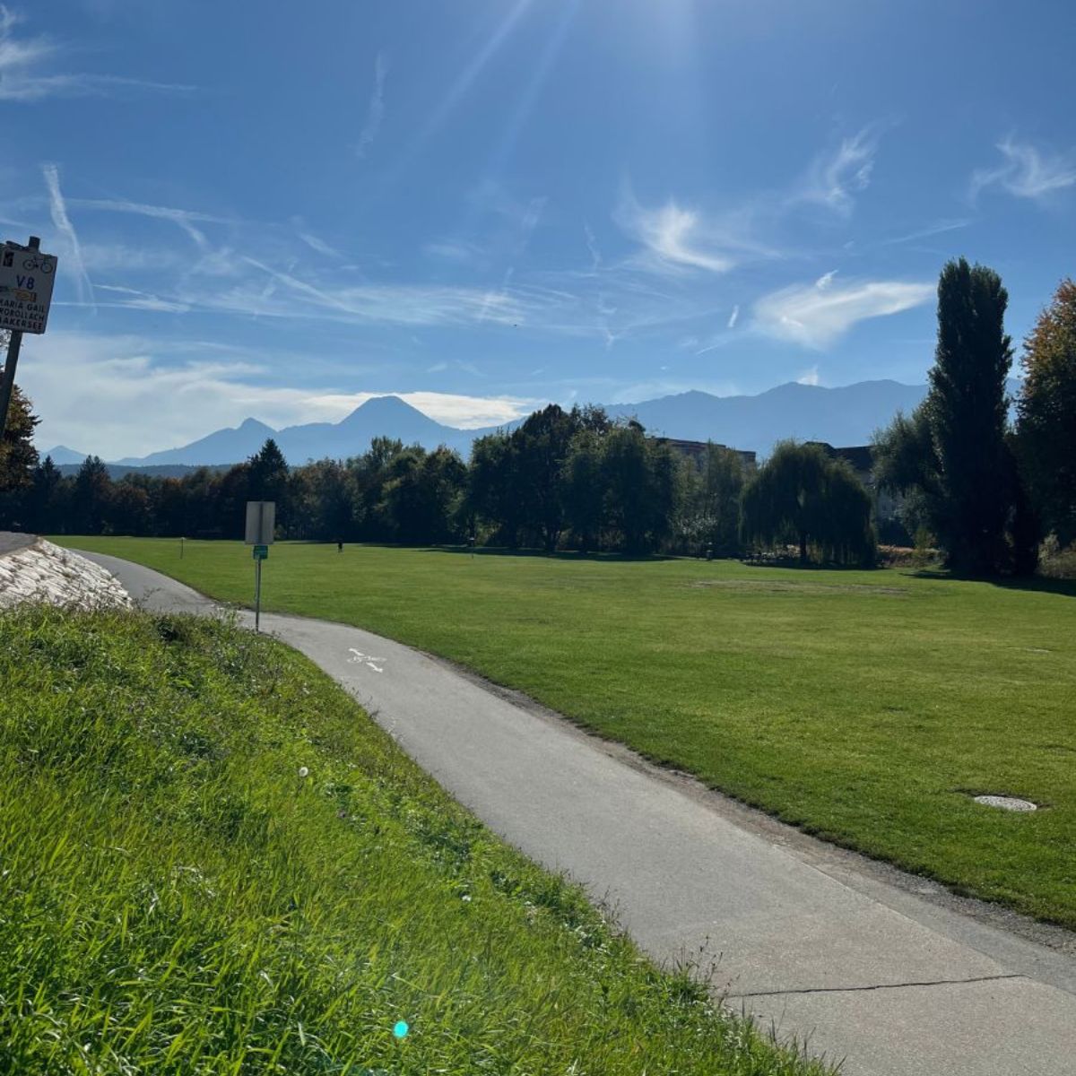 Grüne Parkanlage mit Bergen im Hintergrund