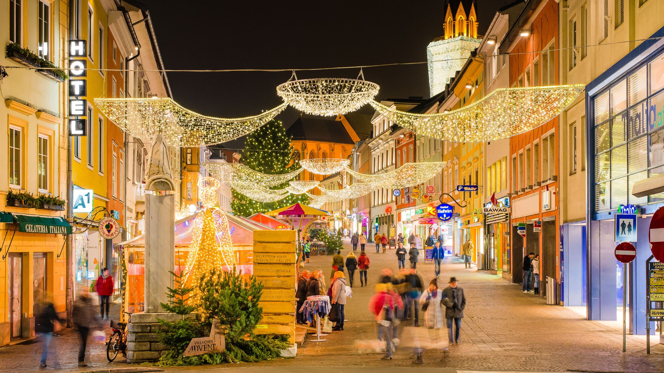 Villacher Innenstadt mit Weihnachtsbeleuchtung und festlich dekorierten Hütten